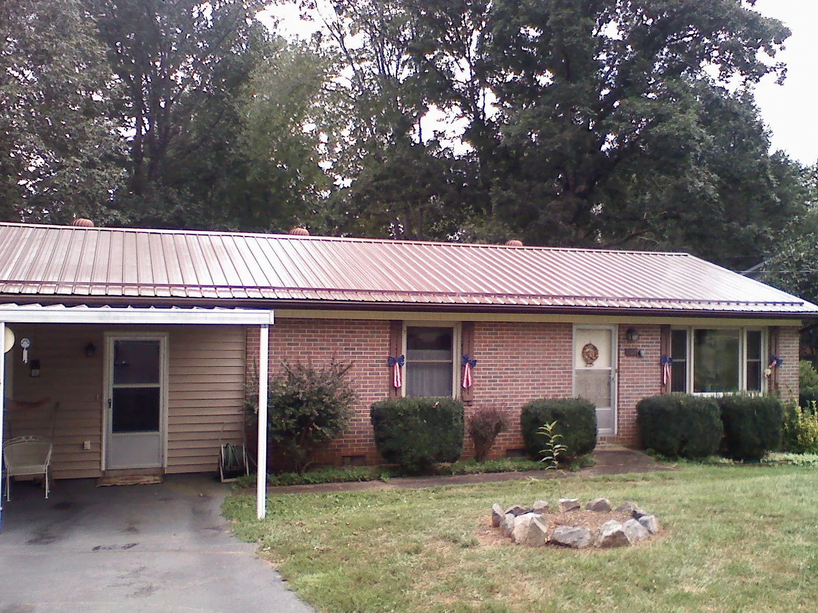 Bronze metal roof and carport on a brick ranch home — Roof Repair work by our crew in Northfield